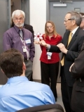 A group of people standing in a room

Description automatically generated