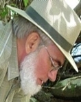 A person with a white beard and a hat

Description automatically generated