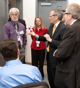 A group of people standing in a room

Description automatically generated