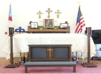 A room with a white bed with a bench and a picture of a person

Description automatically generated