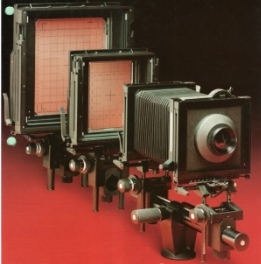Several large cameras on a red background

Description automatically generated