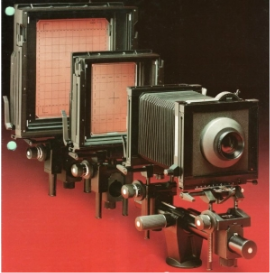 Several large cameras on a red background

Description automatically generated