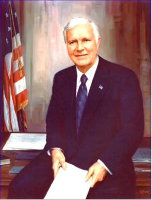 A person in a suit and tie holding a piece of paper

Description automatically generated