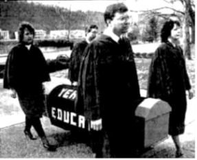 A group of people walking with a coffin

Description automatically generated