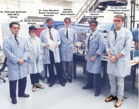 A group of people wearing lab coats and red goggles

Description automatically generated