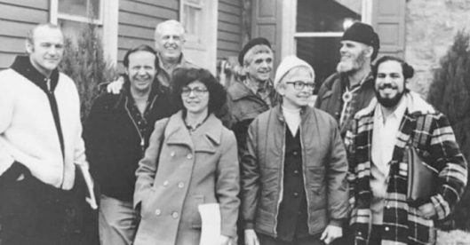 A group of people standing outside a house

Description automatically generated