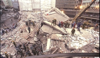 A group of people standing in a pile of rubble

Description automatically generated