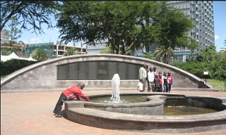 A group of people standing around a fountain

Description automatically generated