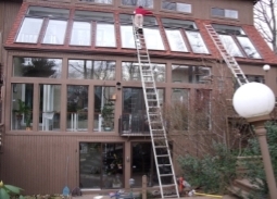 A person on ladders on a house

Description automatically generated